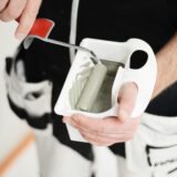 Pieni hyppääjä kädessä pidettävässä maalialustassa